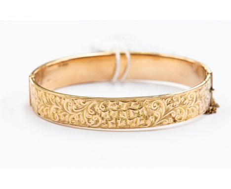 A 9ct gold hinged bangle, scroll decoration, total gross weight 11 grams approx