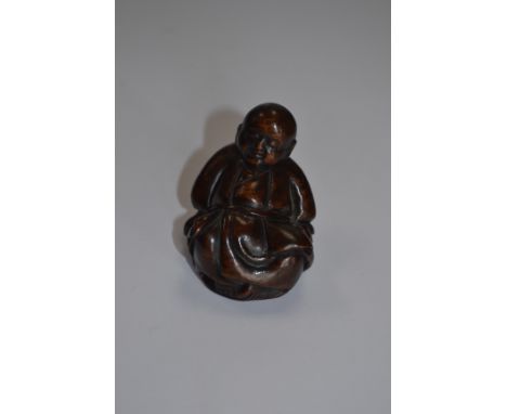 A treen netsuke of a sleeping man 