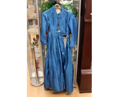 An electric 1870's Victorian dress in silk, with a darker stripe running through the dress, the decorative buttons have a gla