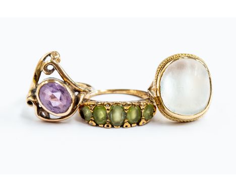 A collection of three gold rings including an amethyst and 9ct gold gold open work dress ring, size K, a 9ct gold and moonsto