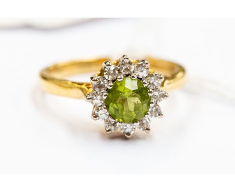 A 18ct gold diamond and peridot cluster ring, round central peridot with diamond surround, size N½, approx 4.8gms