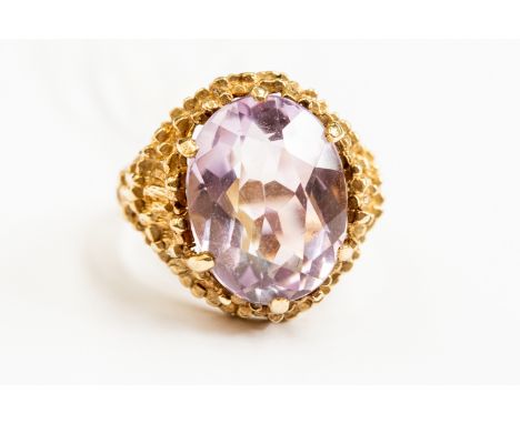 An amethyst and 9ct gold dress ring, oval stone, bark effect mount, 9ct gold, size N, total gross weight approx. 6.6gms.