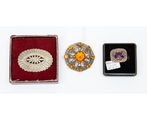 An amethyst silver brooch; Scottish silver and citrine glass brooch;  and a sterling marcasite set brooch (3)