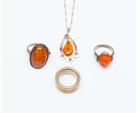 A white metal and amber glass cameo ring; two white metal and amber type rings; a Russian silver and sun spangled amber penda