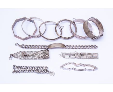 A collection of seven silver bangles including buckle, bamboo, engraved styles and hexagonal versions along with two curb bra