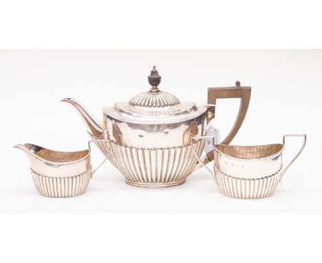 A Victorian silver oval semi fluted teapot and sugar and milk (different hallmarks)