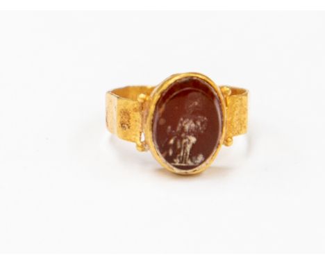 A Roman Empire 2nd/3rd Century AD carnelian intaglio ring, depicting a Roman Deity, yellow goldCondition: Overall good - Inta