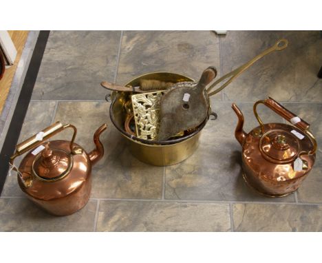 A pair of copper bed warmers with a brass saucepan, pot stand, bellow and table brush, assorted horse brasses and horseshoes,