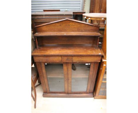 An early Victorian rosewood chiffonier, the upper section with a raised shelf to back, the base with two frieze drawers and t