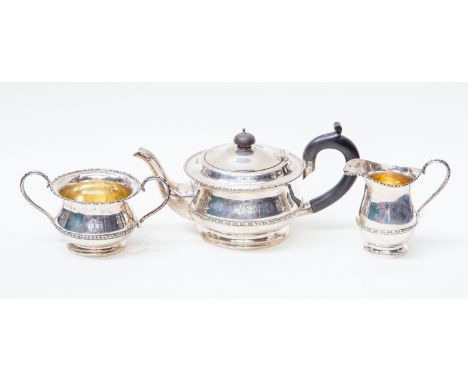 A George V silver three piece tea service, including teapot, sugar bowl and milk jug, plain bodies with egg-and-dart borders,