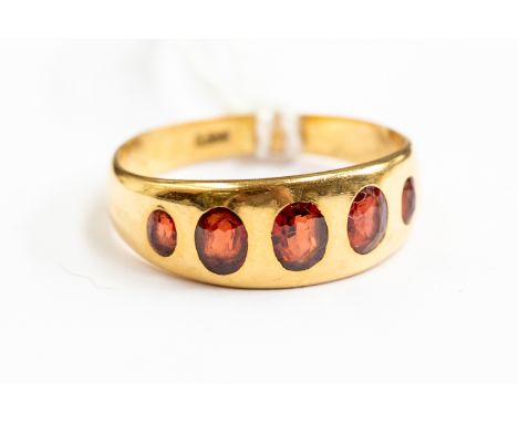 An 18ct gold and garnet dress ring, set with five graduated garnets, size M½, total gross weight approx. 3.9gms.