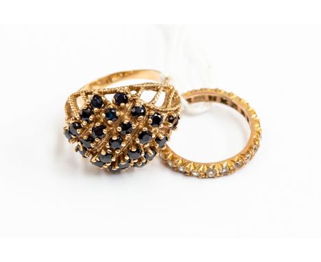 Two 9ct gold rings comprising a sapphire cluster ring, size R, along with a 9ct gold full set eternity ring, paste set, combi