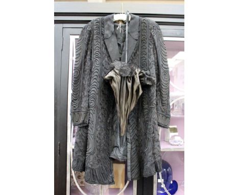 A late Victorian or early Edwardian mourning coat, embellished in lace, fully lined, tassel fastening, label collar, there is