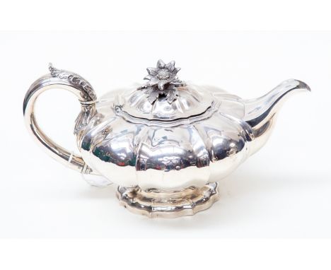 A George IV silver melon shape teapot, footed, with cast flower finial and acanthus leaf handle with ivory insulators, makers