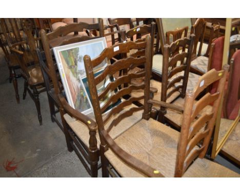 A pair of oak and rush seated ladder back elbow chairs 