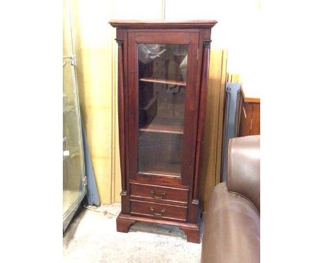 A Georgian inspired mahogany cabinet, with glazed door enclosing shelves and flanked by corinthian type columns, with two dra