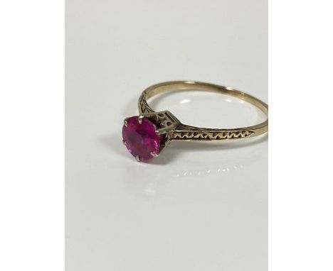 A yellow metal ring mounted solitaire synthetic circular cut ruby mounted in white metal claw setting (Q), unmarked, stone ap