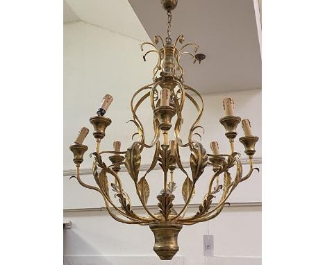 A large giltwood and toleware eight light chandelier, the baluster stem issuing scrolling leaf-cast arms, with ceiling rose a