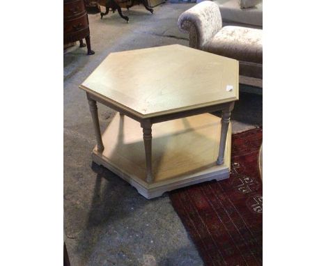 A contemporary light oak veneered coffee table of octagonal outline, the top tier raised on turned supports H45cm, W80cm, D70