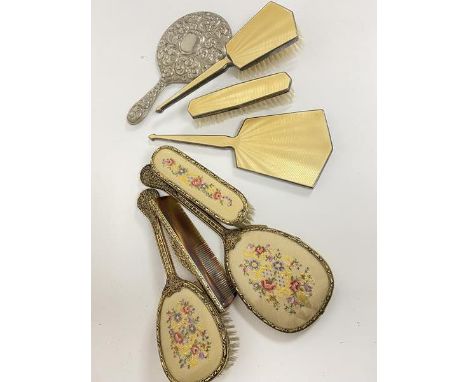 A white metal three piece enamelled dressing table brush set, brush hande a/f, a brass four piece dressing table brush set wi