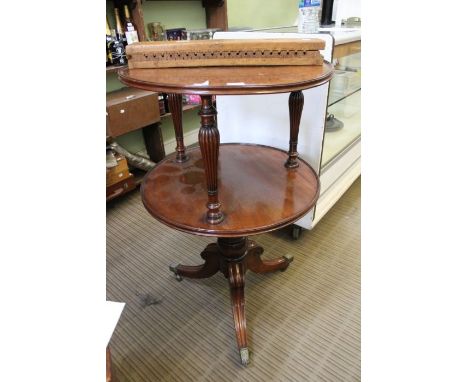 A Regency mahogany circular two tier dumb waiter, with reeded baluster columns on tripod base, 102cm x 62cm dia