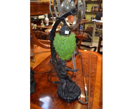 A reproduction cast resin figural table lamp with hanging grape decoration