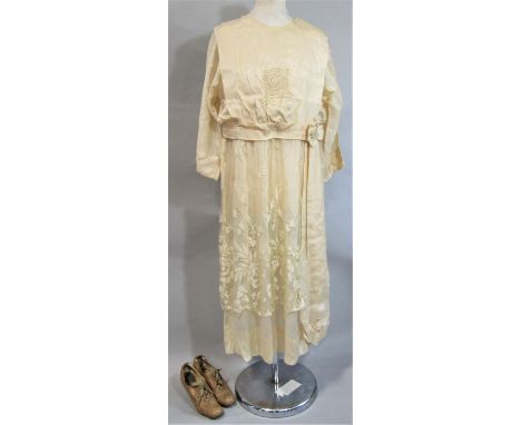 Circa 1920 bridal gown in a cream silk with straight lines, lower waist, round neck, loose fitting sleeves, sash effect at wa