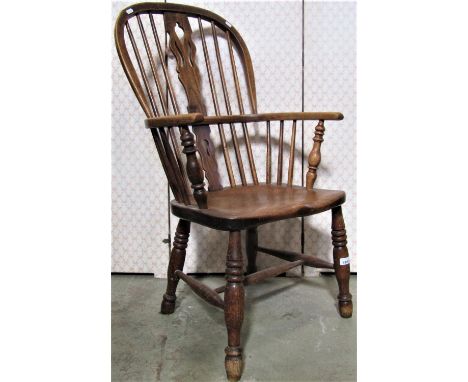 A Georgian Windsor comb back elbow chair principally in elm and ashwood with pierced splats on turned supports 