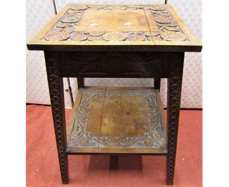 A late 19th century oak occasional table, square cut and of tapering form, on two tiers, with repeating sunflower and scroll 