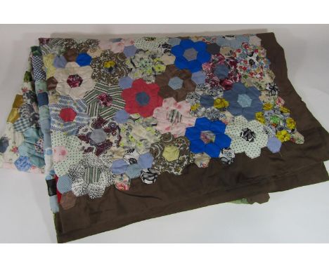 Vintage traditional patchwork quilt with multi coloured hand stitched hexagonal 'flowers' surrounded by a brown border. Lined
