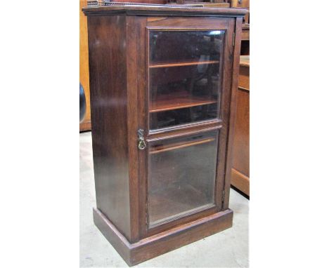 A Victorian rosewood side cabinet enclosed by a glazed panelled door with shelf lined interior, the back with three quarter b