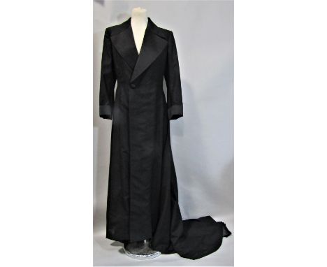 Ladies vintage full length coat with train, in black textured fabric with satin collar, cuffs and covered buttons. Lined in b