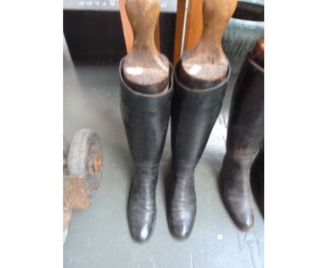 A pair of ladies black leather hunting boots with wooden trees, approximately size 5-6.