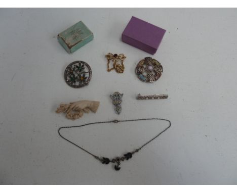 A selection of jewellery including, a Celtic circular brooch, a circular wreath brooch with four gem set flowers, a bone hand