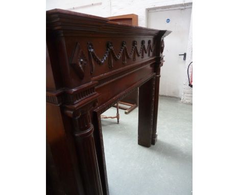 A large 20th century mahogany fire surround, carved in swag and foliage