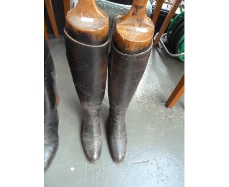 A pair of ladies black leather hunting boots with wooden trees, approximately size 5-6.