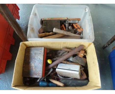 A box of vintage tools including hammers, saws and drill bits