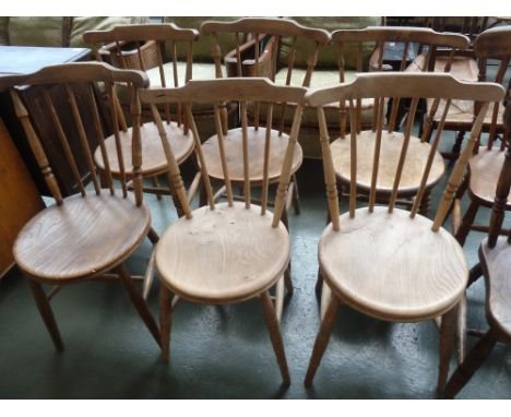 A set of six light elm spindleback chairs, circular seats, with turned legs