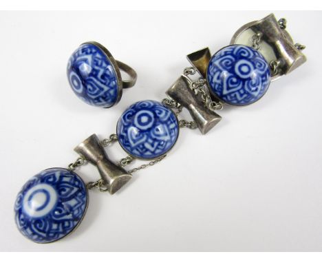 A vintage white metal and ceramic bracelet and ring set, the boss-form flow blue plaques rub set and suspended between white 