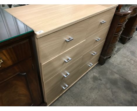 A contemporary light beech eight drawer chest