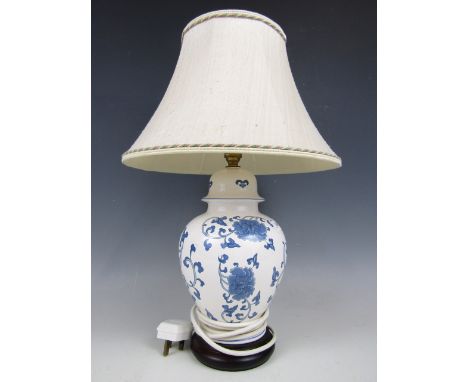 A contemporary ceramic lamp base decorated in a blue and white floral pattern