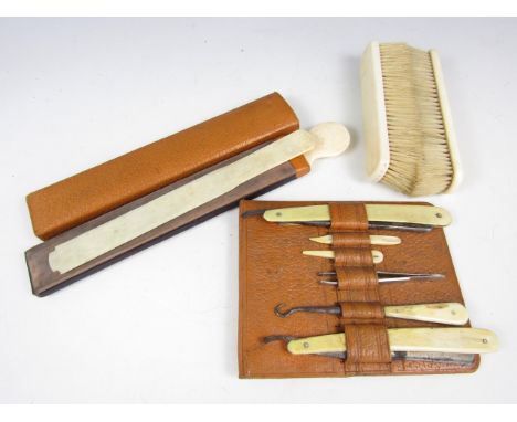 Early 20th Century ivory handled grooming items, including a pair of clothes brushes, a knife strop, cutthroat razors and but