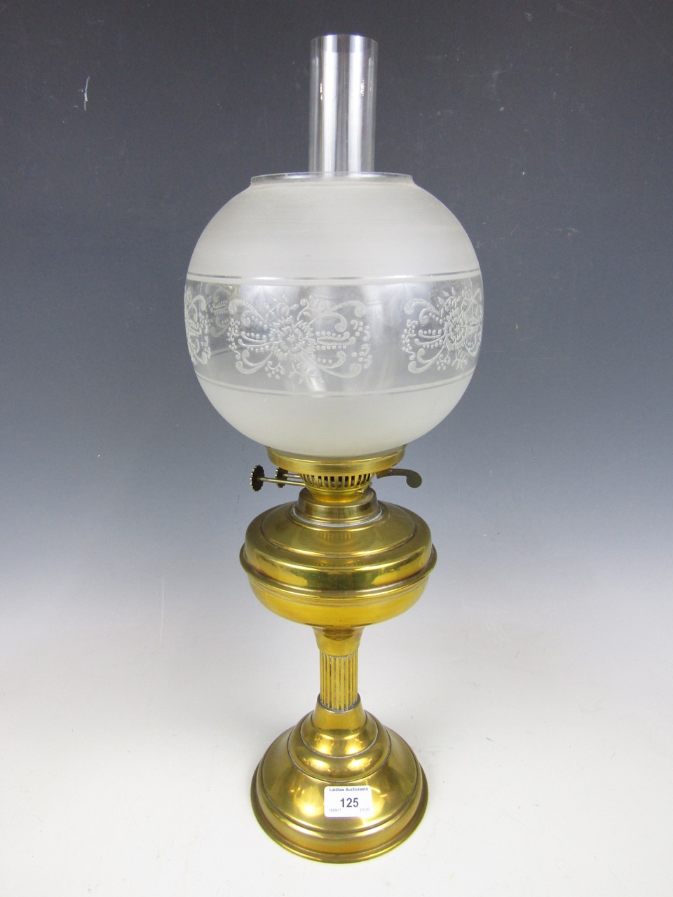 A brass oil lamp with glass globe