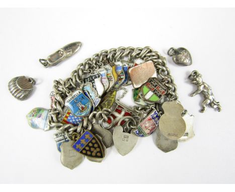 A vintage silver charm bracelet adorned with several enamelled souvenir white metal charms, 54g, together with four novelty w