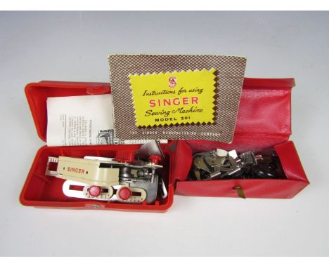 A vintage cased Singer buttonhole attachment implement together with Singer attachments and instruction booklet for model 201