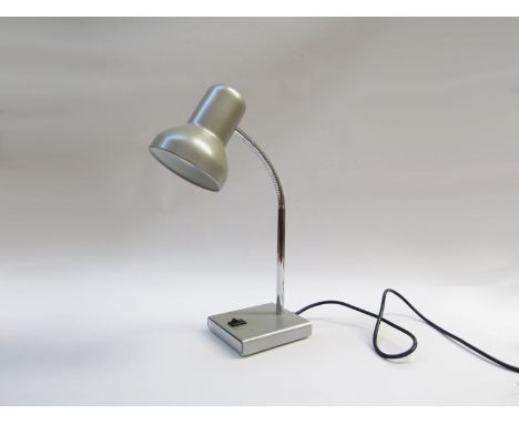 A small desk light in grey and chrome, adjustable single spot