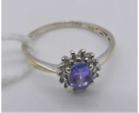 A modern 14ct white gold tanzanite set ring, the oval cut tanzanite weighing 0.5ct, maker QVC, with anchor certificate, size 