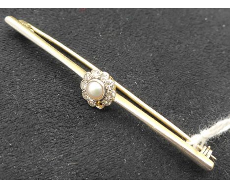 An early 20th century yellow metal and white metal faced bar brooch having a centre flowerhead set with a small pearl within 