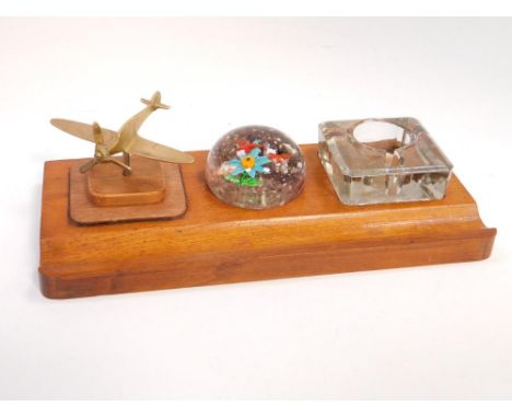 An oak desk stand, with inkwell, Chinese glass paperweight containing butterflies and a flower, and a brass model of a spitfi