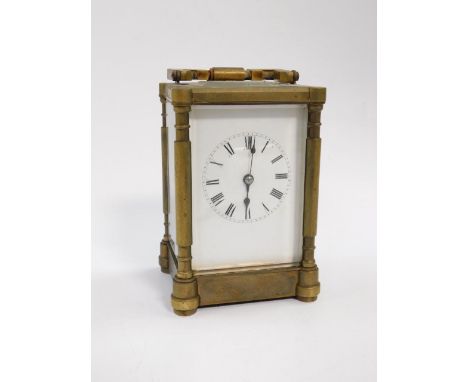 A late 19thC brass carriage clock, white enamel dial bearing Roman numerals, twin  barrel movement with coil strike, with key